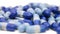 Heap of blue medical capsules rotating on white background