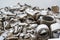 Heap of broken concrete drainage pipes under a thin layer of snow on a construction site, waiting for debris disposal, selected