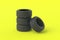 Heap of car rubber tyres on yellow background