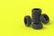 Heap of car rubber tyres on yellow background. Automotive parts