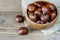 Heap of chestnuts in the bowl on the wooden kitchen background. Healthy fruit chestnuts, vitamins