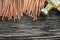 Heap of copper nails claw hammer on wooden board