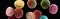 Heap of delicious colorful French macaroons of different flavors isolated on black, panoramic shot.