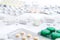 Heap of different pills, in blisters and scattered on white background. Pharmacy and healthcare theme. Medical background
