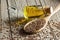 Heap of Flax seeds or linseeds in spoon with glass of linseed oil on wooden backdrop