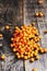 Heap of fresh buckthorn on rustic wooden background