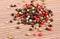 Heap of fresh colored pepper on wooden background