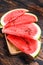 Heap of fresh red sliced watermelon. Dark Wooden background. Top view