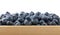 Heap of fresh washed blueberries in wooden box
