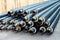 Heap of many new black insulated steel pipes at municipal construction site outdoors. Heating main district pipeline