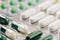 Heap of medical pills in white, green and other colors. Herbal medical pills. Pills in plastic package. Concept of healthcare and
