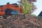 Heap of old bricks and hydraulic bulldozer excavator arm in background