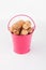 Heap peanut nuts in pink bucket on white background