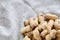 Heap of peanuts on light tablecloth, close-up, shallow depth of field, selective focus, macro