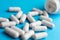 Heap of pills or tablets capsule plastic drugs bottle blue background