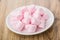 Heap of pink chewing marshmallow in white saucer on table
