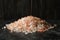 Heap of pink himalayan salt on black smokey table