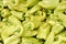 Heap of pointed sweet white bell peppers displayed on food market, closeup detail