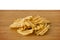 Heap of potato chips on a wooden board