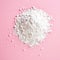 Heap of powder sugar on pink, from above