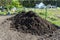 A heap of pure black earth lying in the yard next to the fence.
