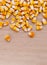 Heap of raw corns seeds, maize or sweetcorn kernels top view on wooden background.
