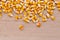 Heap of raw corns seeds, maize or sweetcorn kernels top view on wooden background.