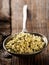 Heap of raw, organic hemp seeds in metal scoop on brown rustic wooden table