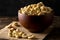 Heap of raw, organic, whole cashew nut kernels in wooden bowl on