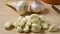 Heap of raw peeled garlic with fresh picked garlic in the background