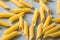 Heap raw penne pasta on ultimate gray background