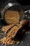 Heap of raw, unprocessed mustard seed kernels in glass jar and w