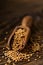 Heap of raw, unprocessed mustard seed kernels in wooden scoop on