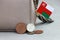 Heap of Rial Omani coin money and mini Oman flag with the leather wallet on grey background