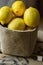 Heap of Ripe Organic Lemons in Jute Sack Standing on Wood Garden Box. Rustic Kinfolk Style. Atmospheric Mood Cozy Atmosphere.