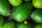 Heap of ripe raw avocados on dark stone background. Top view. Copy space. Healthy lifestyle vitamins oil mediterranean cuisine