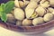 Heap salted pistachio nuts on wooden spoon background