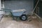 Heap of sand in a wheelbarrow with a shovel are standing at the building site