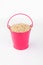 Heap sesame grains in pink bucket on white background