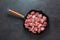 Heap small pieces raw meat in frying pan  top view