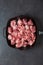 Heap small pieces raw meat in frying pan  top view