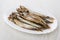 Heap of smoked capelin in oval dish on table