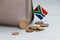 Heap of South African Rand coin money and mini South African flag stick on the leather wallet on grey background