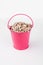 Heap sunflower seeds in pink bucket on white background