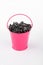 Heap sunflower seeds in pink bucket on white background