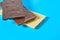 Heap of three various whole porous chocolate bars lies on blue table on kitchen
