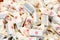 A heap of traditional small Polish fudge candy packed in white paper macro, closeup. Lots of sweet sugar treats, fudge container