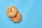 Heap of two fresh circle oat cookies with hole and peanuts lies on blue desk on kitchen. Space for text