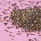 Heap of uncooked linen seeds on a pink background. Close up. Healthy superfood Concept.