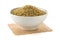 Heap of uncooked, raw freekeh or firik, roasted wheat grain, in white bowl over white